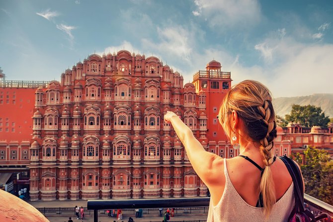 Foreigner woman admiring Pink City in Jaipur, highlighting hourly cab services for sightseeing, flexible city tours, and premium chauffeur-driven travel.