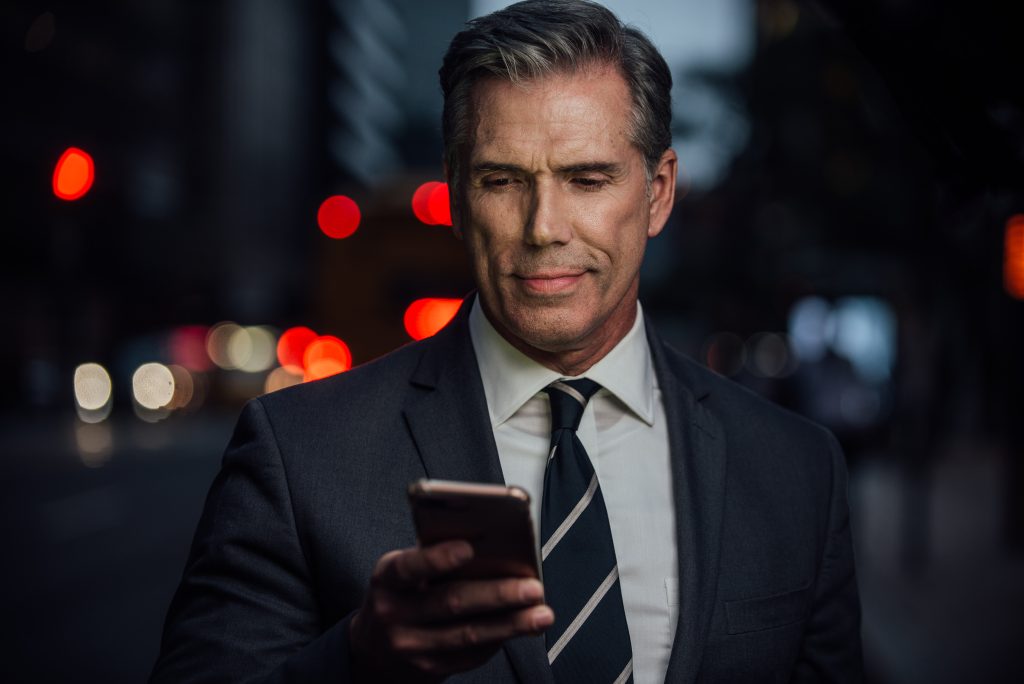 Portrait of a confident businessman in a tailored suit, set against a city backdrop, showcasing executive leadership and a modern urban lifestyle.