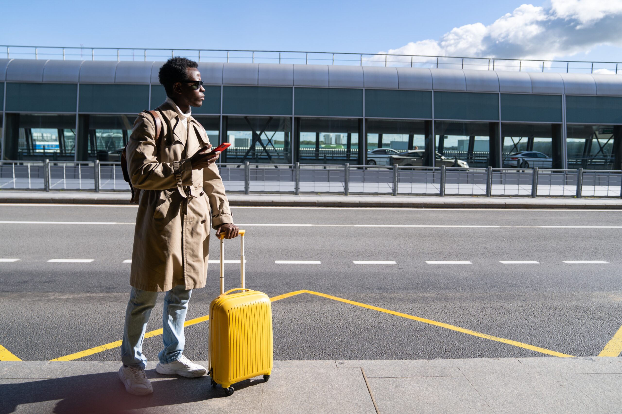 Man standing in airport with suitcase, traveler preparing for flight, business and leisure travel concept, airport terminal
