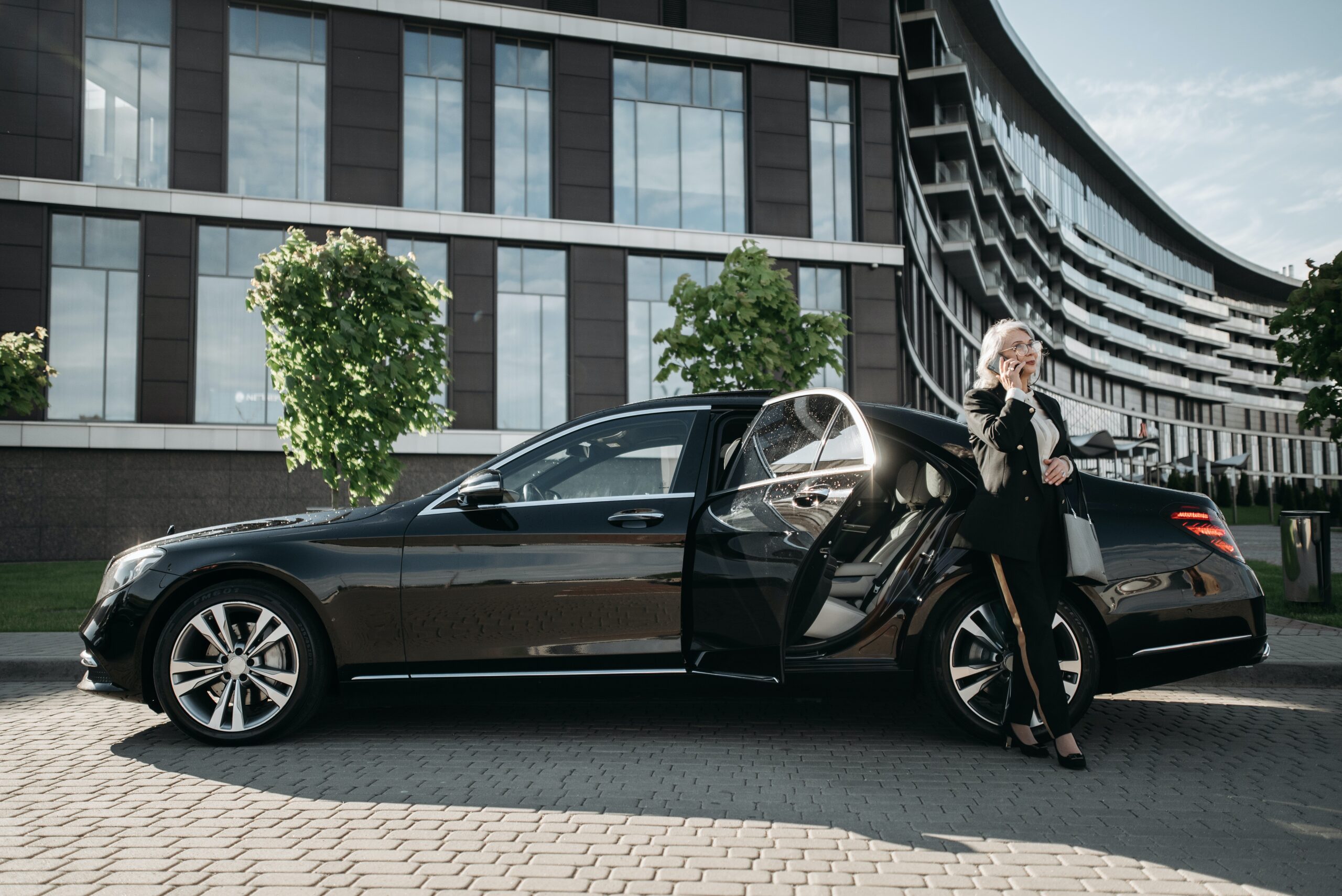Banner image showing a luxurious black car with a happy customer ready for a premium chauffeur service, ideal for corporate, business, and airport transfers.