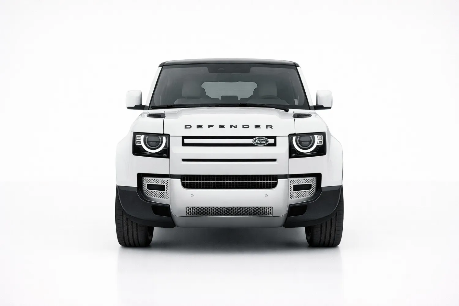 Land Rover Defender front view showing bold grille, round LED headlights, and off-road stance